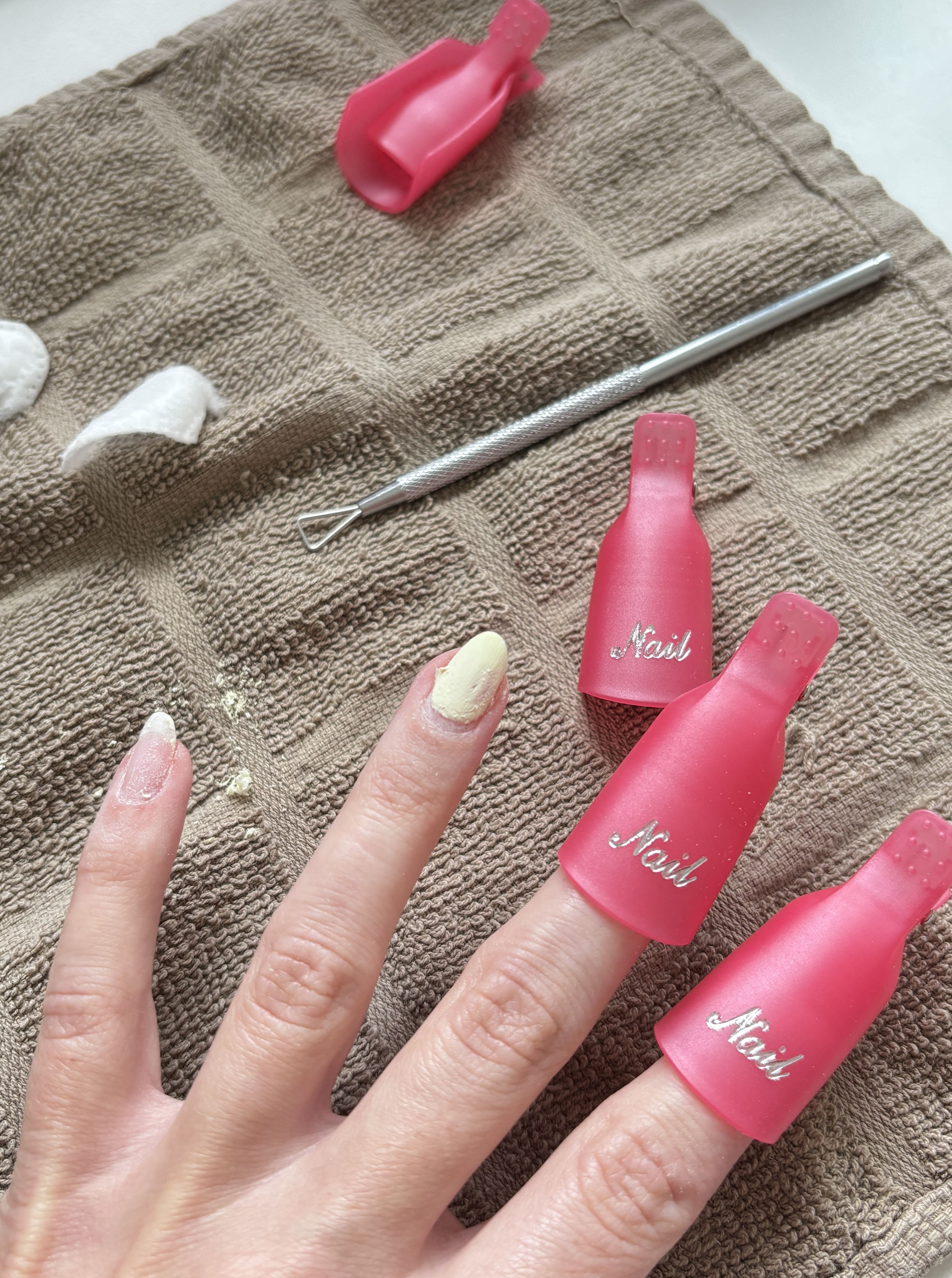 plastic clips covering fingernails soaking in acetone for gel polish removal